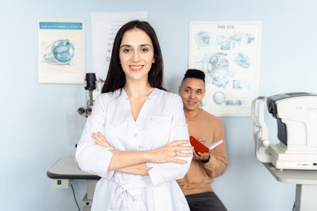 Portrait of a confident female doctor smiling with arms crossed in a medical office setting.